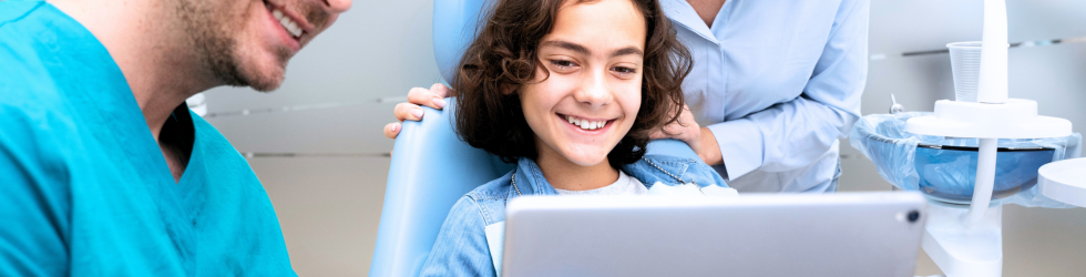 especialista-en-ortopedia-dentofacial-explicando-tratamiento-digital-a-paciente-infantil