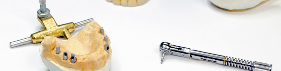 Modelo dental junto a llave de implantes