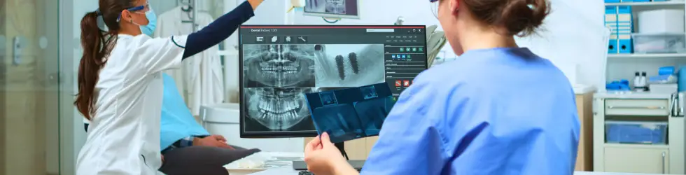 Odontólogo evaluando una tomografía para la valoración del daño dental y peritaje judicial