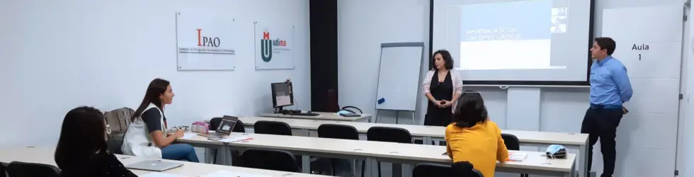 Clase presencial o debate de casos clínicos entre odontólogos y el docente en las instalaciones de IPAO Madrid.